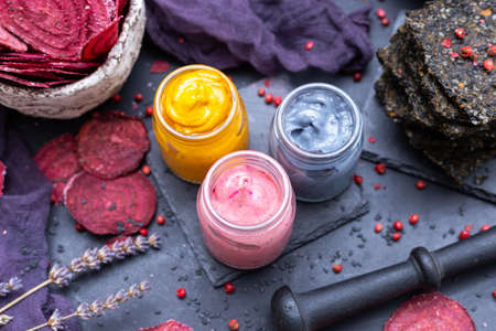 A high angle view of spices for vegan food in small jars on the table with dehydrated beetrootsの写真素材