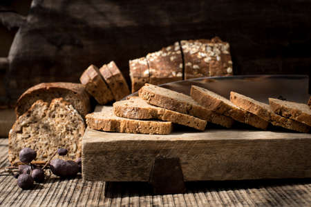 A closeup still photography shot of sliced bread on a wooden deskの写真素材