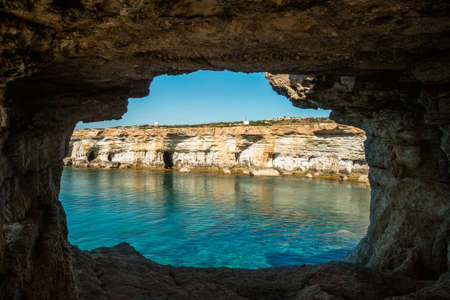 A wide angle shot of the ocean seen through a caveの写真素材