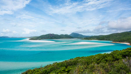 A beautiful shot of a beach surrounded by mountains under a blue skyの写真素材