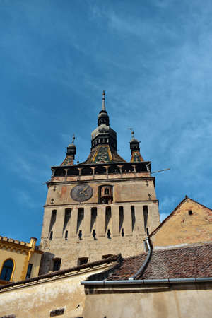 A vertical low angle shot of the Clock Tower Sighisoara in Romania under the pure blue skyの写真素材