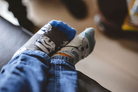 A closeup shot of the legs of a little boy in socks with a blurry backgroundの写真素材
