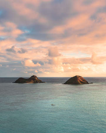 A beautiful shot of small hills in the sea under the beautiful cloudy skyの写真素材