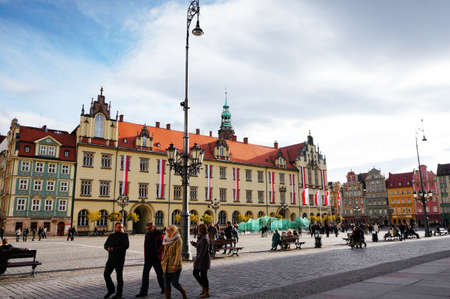 WROCLAW, POLAND - Nov 10, 2013: Sitting and walking people close by the new city hall in the old...