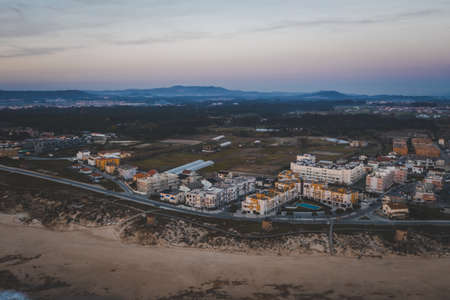 The bird's eye view of a city with old buildings in the evening with mountains in the background