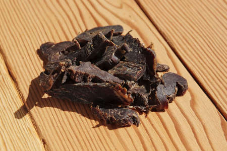 Biltong (dried meat) on a wooden board, this is a traditional food snack that can be found in South Africa.の写真素材