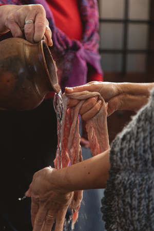 A vertical closeup of people washing raw meat with hot water under the lightsの写真素材