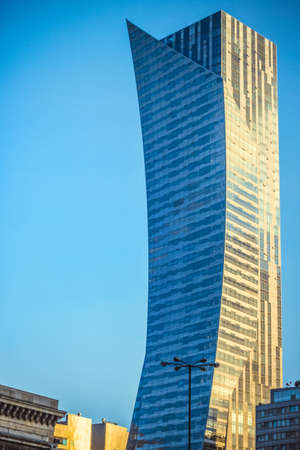 A vertical shot of a large skyscraper under the blue sky