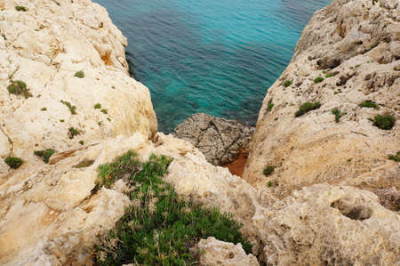 Brown rocks and a blue sea in Cyprus during daytimeの写真素材
