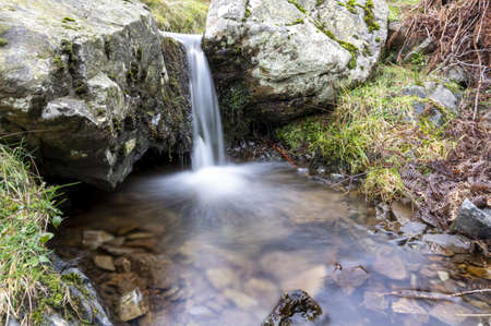 A small waterfall with pure water and stones