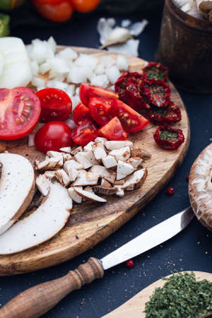 A selective focus shot of fresh tomatoes and sliced mushroom with a blurred background