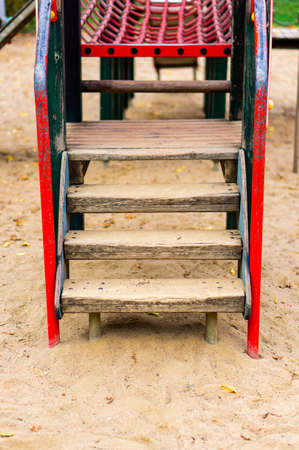 The wooden stairs in the playground on the sand in the park