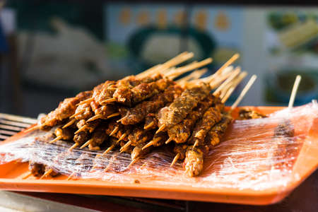 A selective focus shot of raw meat on the stickの写真素材