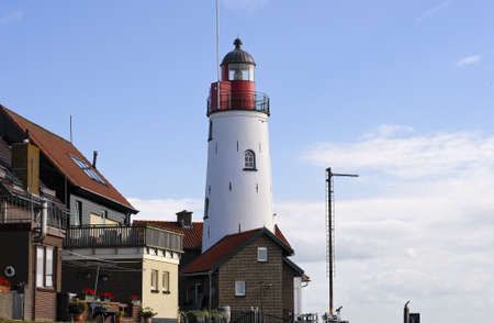 A beautiful shot of Urk Lighthouse in the Netherlands with a cloudy blue sky in the backgroundの写真素材