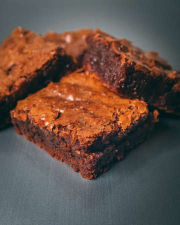 A closeup shot of moist brownies on black surface