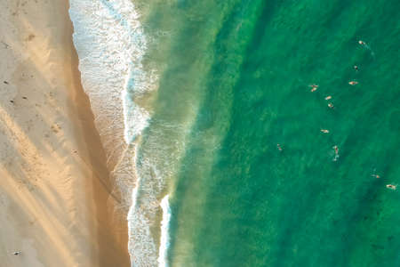 top view drone shot of green water with surfer in Tofo, Mozambiqueの写真素材