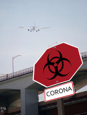 A vertical shot of a coronavirus road sign information message and an airplane in the background