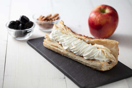 A beautiful shot of the creamy dessert on the plate, with an apple, almond and dried fruits next to itの写真素材