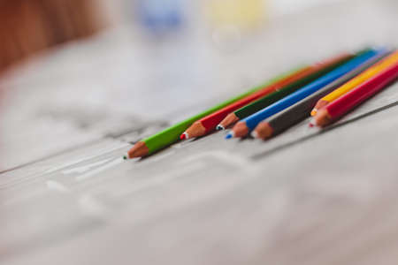 A closeup shot of colorful drawing pencils on a blurry surface