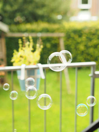 A vertical shot of several bubbles in the air on a green field