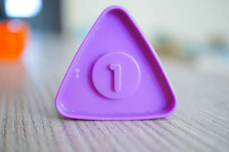 A closeup shot f a purple triangle shaped plastic toy with the number oneの写真素材