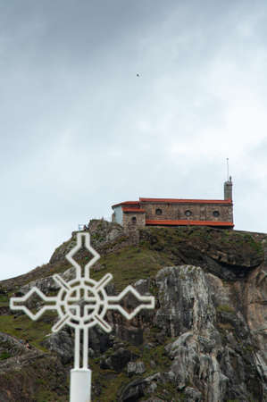 A vertical shot of an old building on top of a cliff in San Juan de Gaztelugatxe, Bermeo, Spain