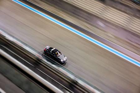 January 25, 2019 - Abu Dhabi, UAE: High angle panning shot of Porsche car racing at Yas Marina Circuit at nightのeditorial素材