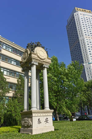 A vertical shot of a statue in a park surrounded by buildingsのeditorial素材