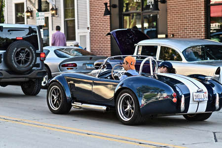 DOWNERS GROVE, UNITED STATES - Jun 07, 2019: A man driving a shiny vintage car in a busy street of downers grove USAのeditorial素材