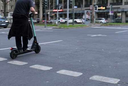 DÃ¼SSELDORF, GERMANY - Sep 09, 2019: 09 September 2019 - DÃ¼sseldorf, Germany: A man using one of the many e-scooters in the city.のeditorial素材