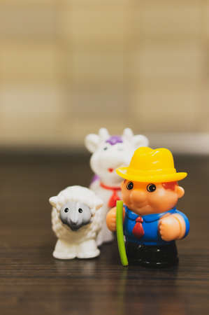 POZNAN, POLAND - Jan 16, 2019: Plastic toy farmer and animal on a wooden surface.のeditorial素材