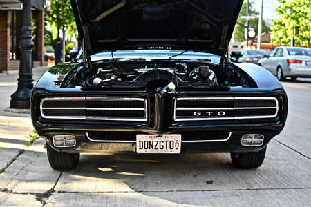 DOWNERS GROVE, UNITED STATES - Jun 07, 2019: A shiny black pontiac gto car with an open hood showing...