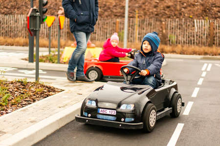 KOWNATY, POLAND - Jan 06, 2019: Young boy sitting in a small cart on a practicing track in the Majaland attraction park.
