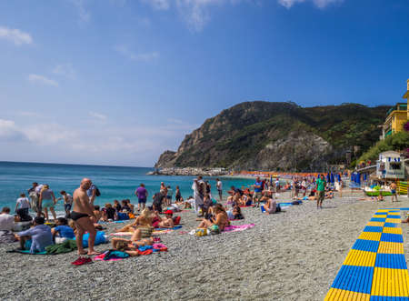MONTEROSSO, ITALY - Jul 07, 2019: The sea and sandy beach Spiaggia di Fegina at the Cinque Terre Italy resort village of Monterosso al Mare with tourists enjoying the Italian Rivieraのeditorial素材
