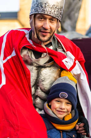 POZNAN, POLAND - Nov 11, 2019: Young smiling boy standing next to a man in a Roman soldier costume during the Independence day event in the city center.のeditorial素材