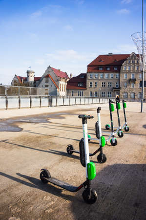POZNAN, POLAND - Feb 06, 2019: Row of parked rental electric scooters on a wide sidewalk in the city...