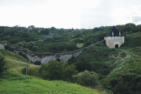 A wide angle shot of the Khotyn Fortress in Ukraine surroudned by grass and trees