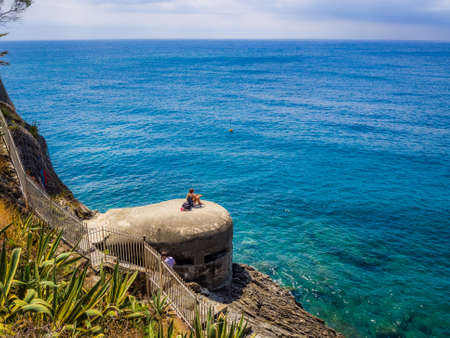 MONTEROSSO, ITALY - Jul 07, 2019: The sea and sandy beach Spiaggia di Fegina at the Cinque Terre Italy resort village of Monterosso al Mare with tourists enjoying the Italian Rivieraのeditorial素材