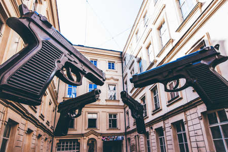 A closeup shot of giant guns in the middle of buildings of Artbanka Museum of Art Young in Prague,...