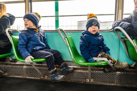 POZNAN, POLAND - Nov 24, 2019: Children sitting on green seats of a old tram during the MPK Katarzynki event.のeditorial素材
