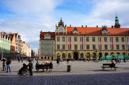 Wroclaw, Poland - November 10, 2013: Sitting and walking people close by the new city hall in the...