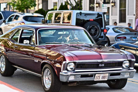 DOWNERS GROVE, UNITED STATES - Jun 07, 2019: A selective focus shot of a man driving his maroon...