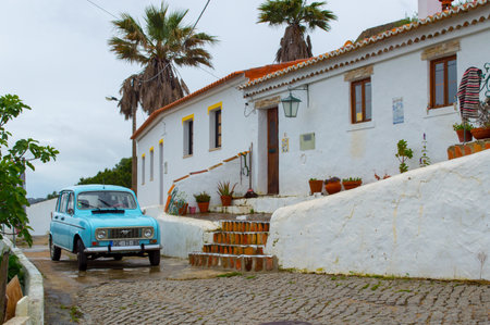 ALJEZUR, PORTUGAL - May 09, 2018: Village street in ALjezur, Southwest Portugal with a bright coloured car parked next to itのeditorial素材