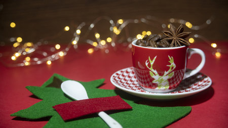 A selective focus shot of coffee beans and star anise in a Christmas coffee cup and Christmas decorsの写真素材