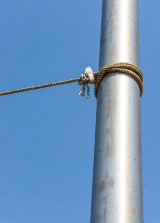 A thick rope tied around the tube with the blue sky in the background