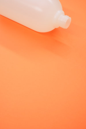A vertical shot of a plastic bottle on an orange backgroundの写真素材