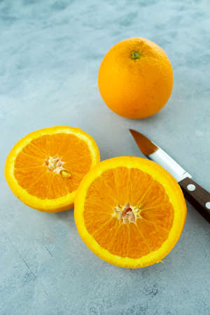 A vertical shot of sliced fresh orange fruit on a concrete surface