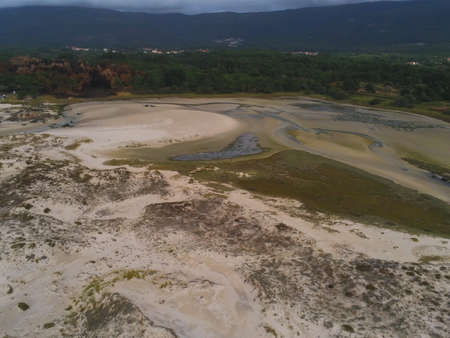 A landscape of the beach surrounded by hills covered in greenery in Carnota in Spain