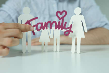 The white icons of people depicting a family and a man holding a purple family stickerの写真素材