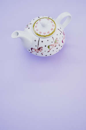 A vertical shot of decorative teapot isolated on purple backgroundの写真素材